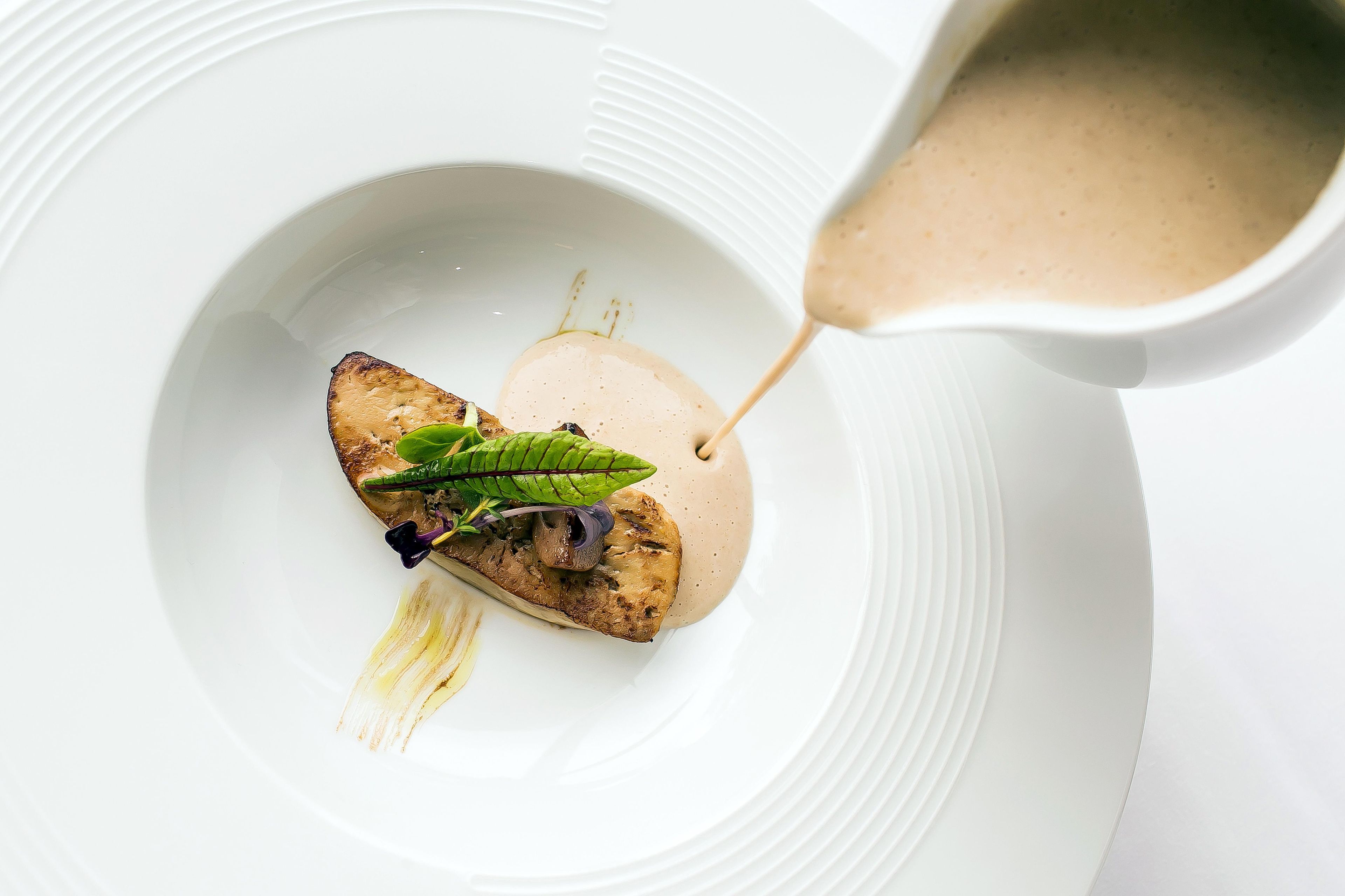 Un plato blanco con comida y salsa.