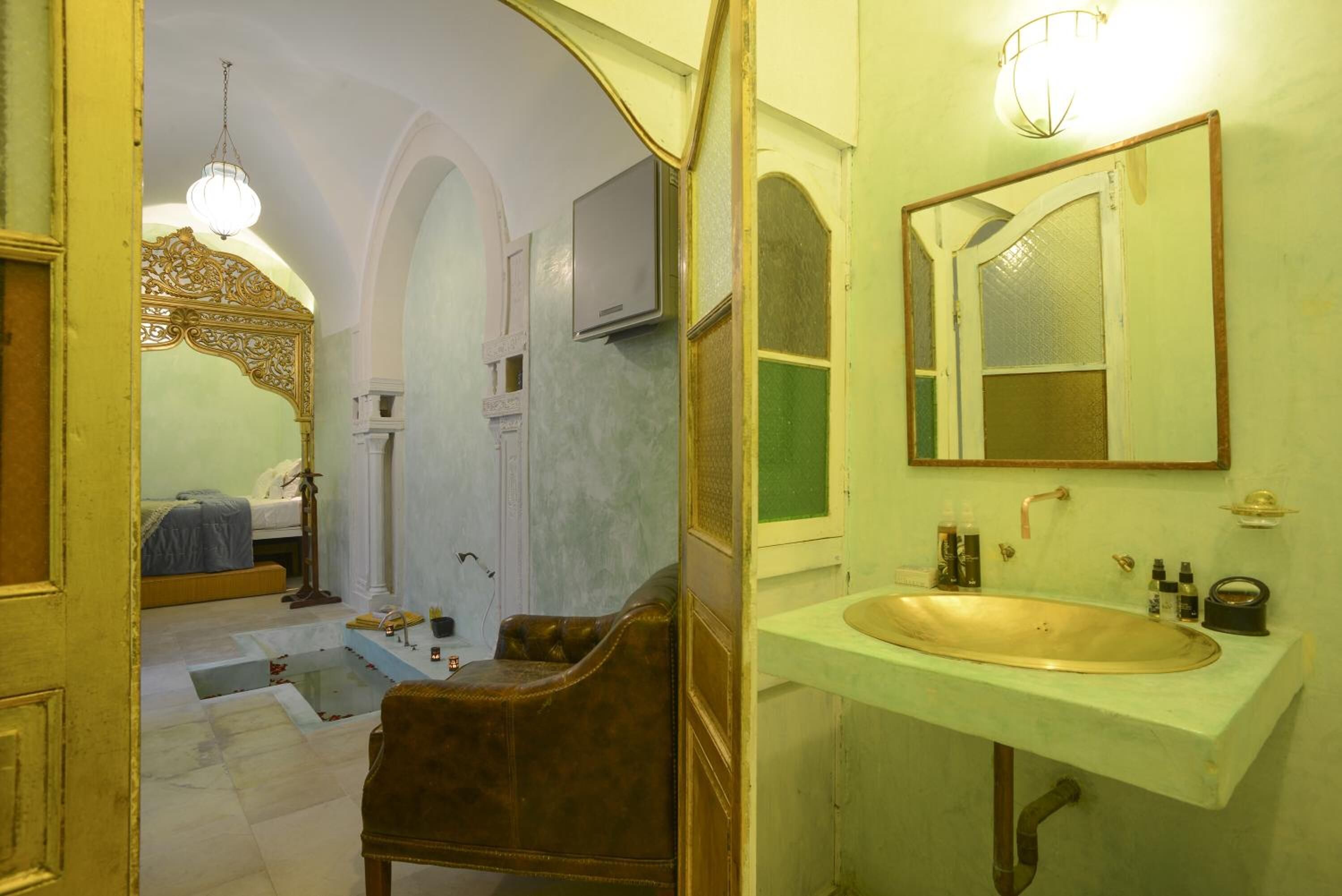 A bathroom with a large mirror, a sink, and a chair.