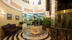 A luxurious lobby with a grand chandelier, a round table, and a sofa. - Boutique Hotel Buta (Minsk)
