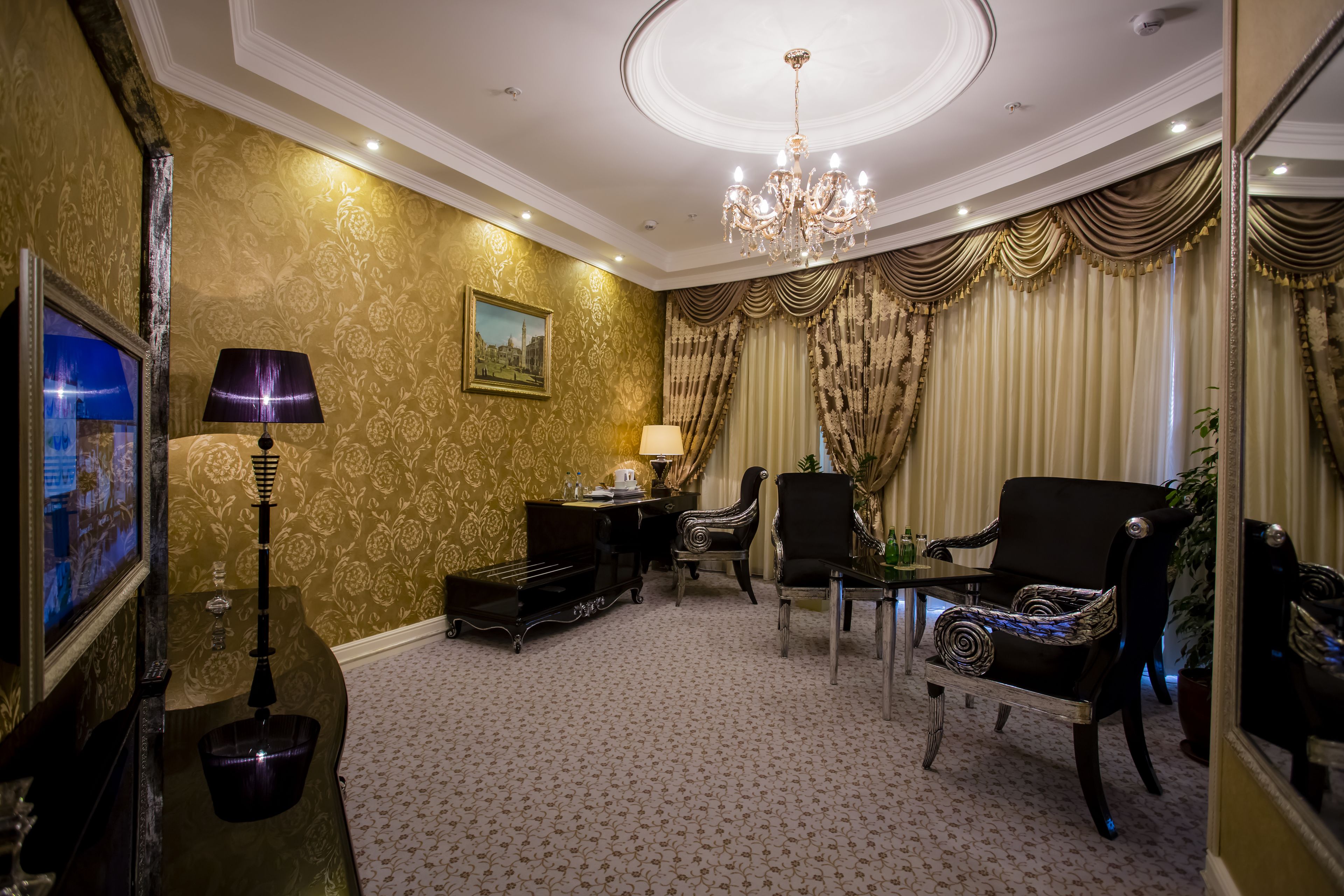 Ein luxuriöses Zimmer mit einem prächtigen Kronleuchter, aufwendigen Vorhängen und klassischen Möbeln, darunter ein Klavier und Sessel.