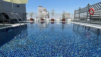 Una piscina al aire libre, sillones reclinables de piscina