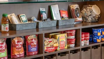 Uma prateleira cheia de diversos alimentos, incluindo arroz, especiarias e refeições prontas.
