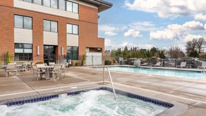 A modern building with a brick facade, a pool area with a hot tub, and outdoor seating. - Best Western Premier Boulder Falls Inn (Lebanon)