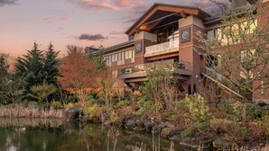 A modern building with a reflective pond, surrounded by autumn foliage and a clear sky. - Best Western Premier Boulder Falls Inn (Lebanon)