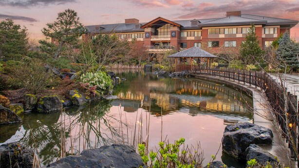 A building with a pond, surrounded by trees and rocks. - Best Western Premier Boulder Falls Inn (Lebanon)