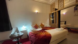 A hotel room with a bed, bedside tables, a desk, and a chair.