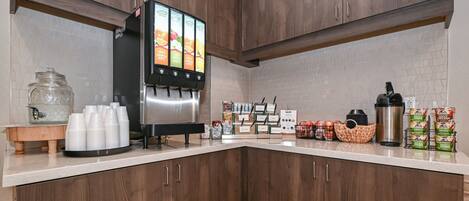 A kitchen with wooden cabinets, a coffee machine, and various food items on the counter.