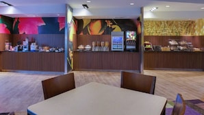 A restaurant area with a counter, seating, and a mural.