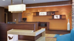 A reception area with a wooden reception desk, a sign reading "Connect & Print," and a wall-mounted shelf with decorative items.