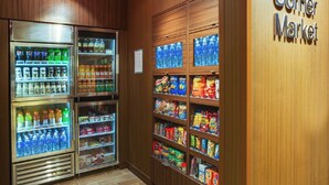 A Corner Market with refrigerated beverage dispensers and shelves stocked with snacks and beverages.