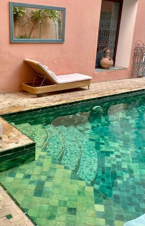 A pool with mosaic tiles, a lounge chair, and a small window with a decorative pot. - Palais Riad Lamrani (Marrakech)