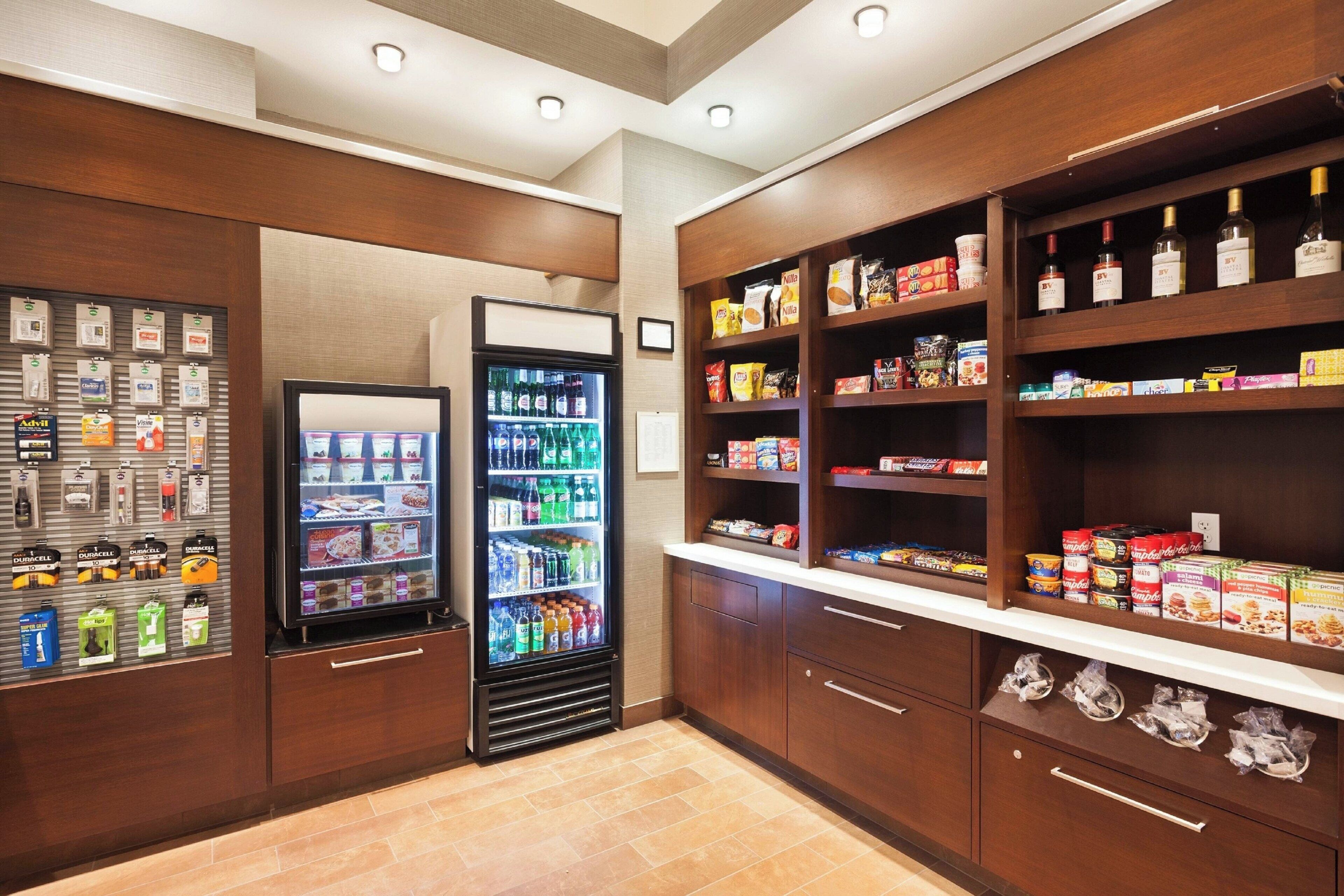 A hotel pantry with shelves stocked with snacks, beverages, and condiments.