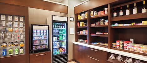 A hotel pantry with shelves stocked with snacks, beverages, and condiments.