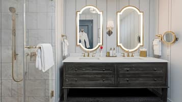 A bathroom with a glass shower enclosure, a vanity with two mirrors, and a dark wooden cabinet.
