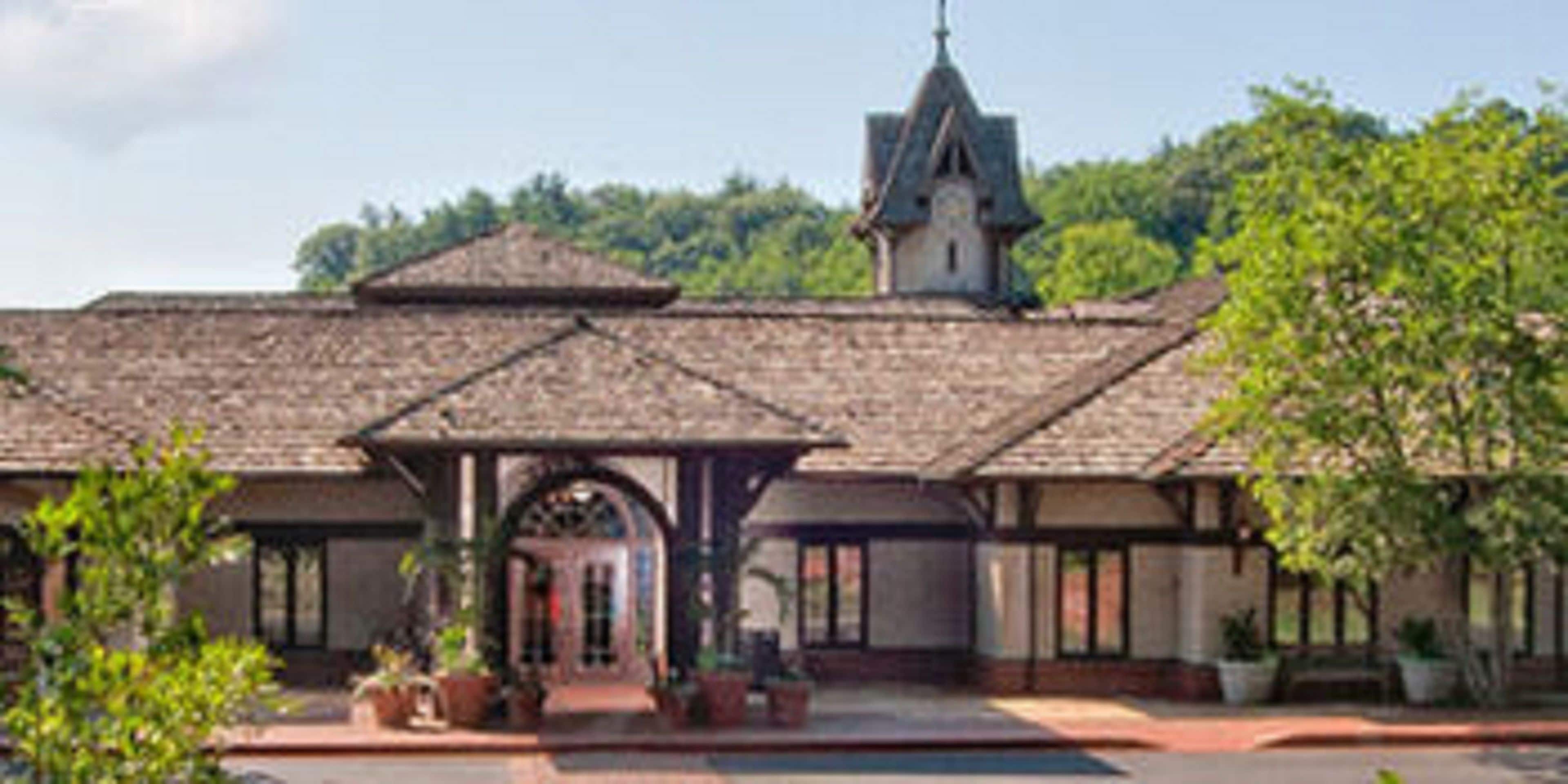 A building with a tiled roof, a central archway, and a bell tower.