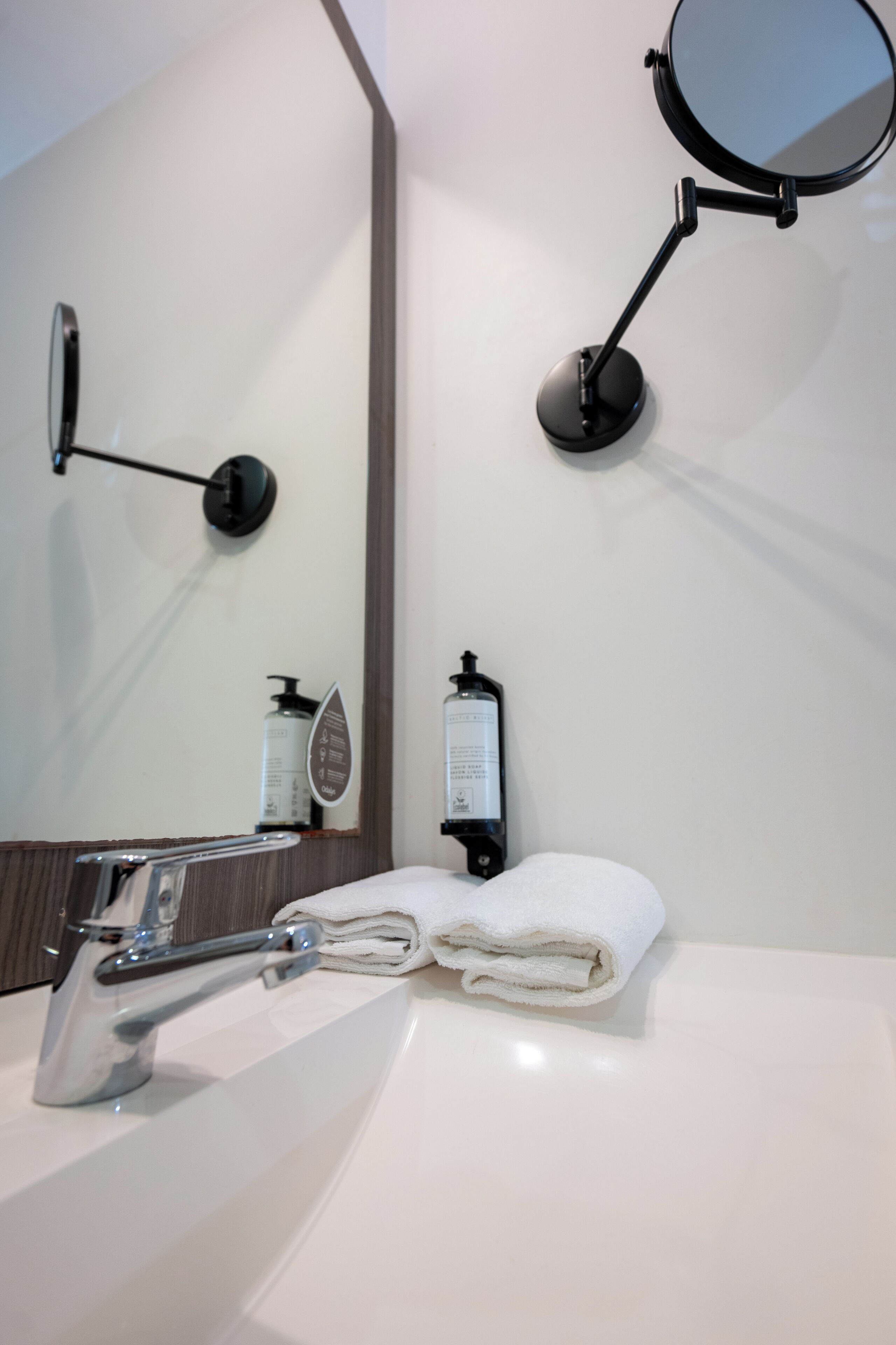 A bathroom with a white sink, a mirror, and a towel.