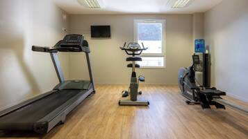 Un gimnasio con cinta de correr, elíptica y bicicleta estática.