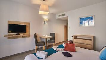 Habitación de hotel con cama, televisión, escritorio y silla.