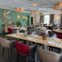 Un restaurante con varias mesas dispuestas para comer, que presenta una mezcla de decoración moderna y rústica.