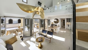 Amplia sala de estar con techo alto, comedor y cocina. Un ventanal grande ofrece vistas al exterior.
