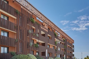 A multi-story building with balconies, windows, and a clear sky.