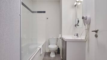 Un baño con inodoro, lavamanos y ducha.