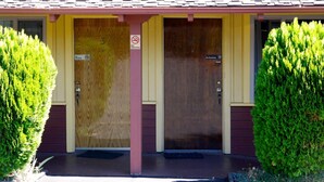 Un bâtiment doté de deux portes, chacune étant signalée par un panneau indiquant « Il est interdit de fumer ».