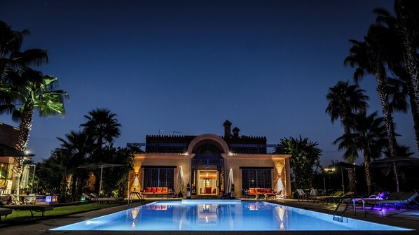 A hotel with a swimming pool, palm trees, and a night sky. - Casa Taos (Saâda)