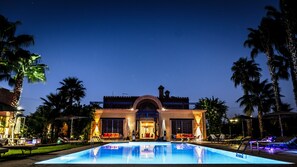 Una piscina al aire libre, camas de piscina gratis, sombrillas