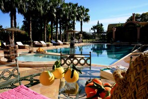 Una piscina al aire libre, camas de piscina gratis, sombrillas