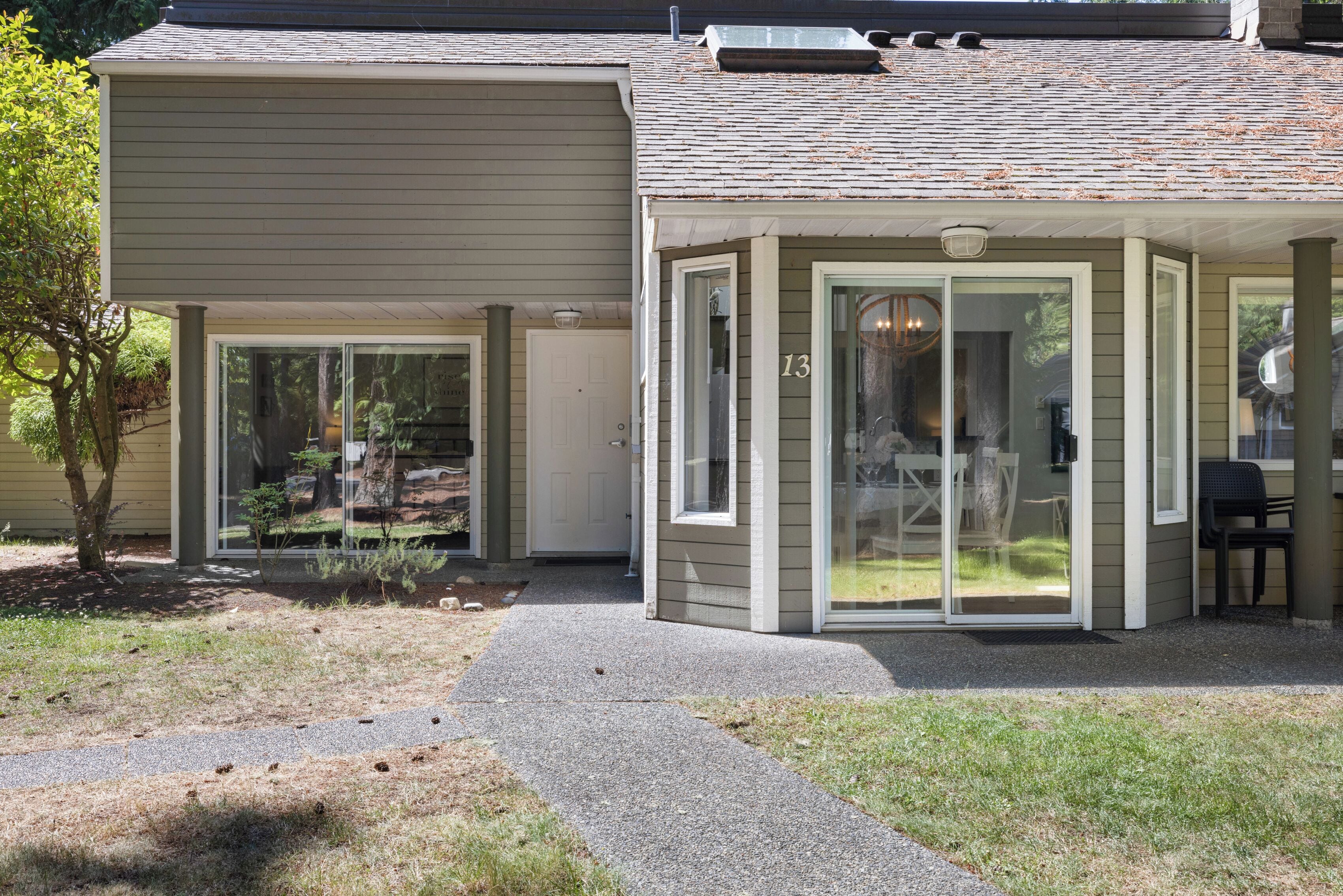 A house with a covered patio, a visible door, and a small garden area.