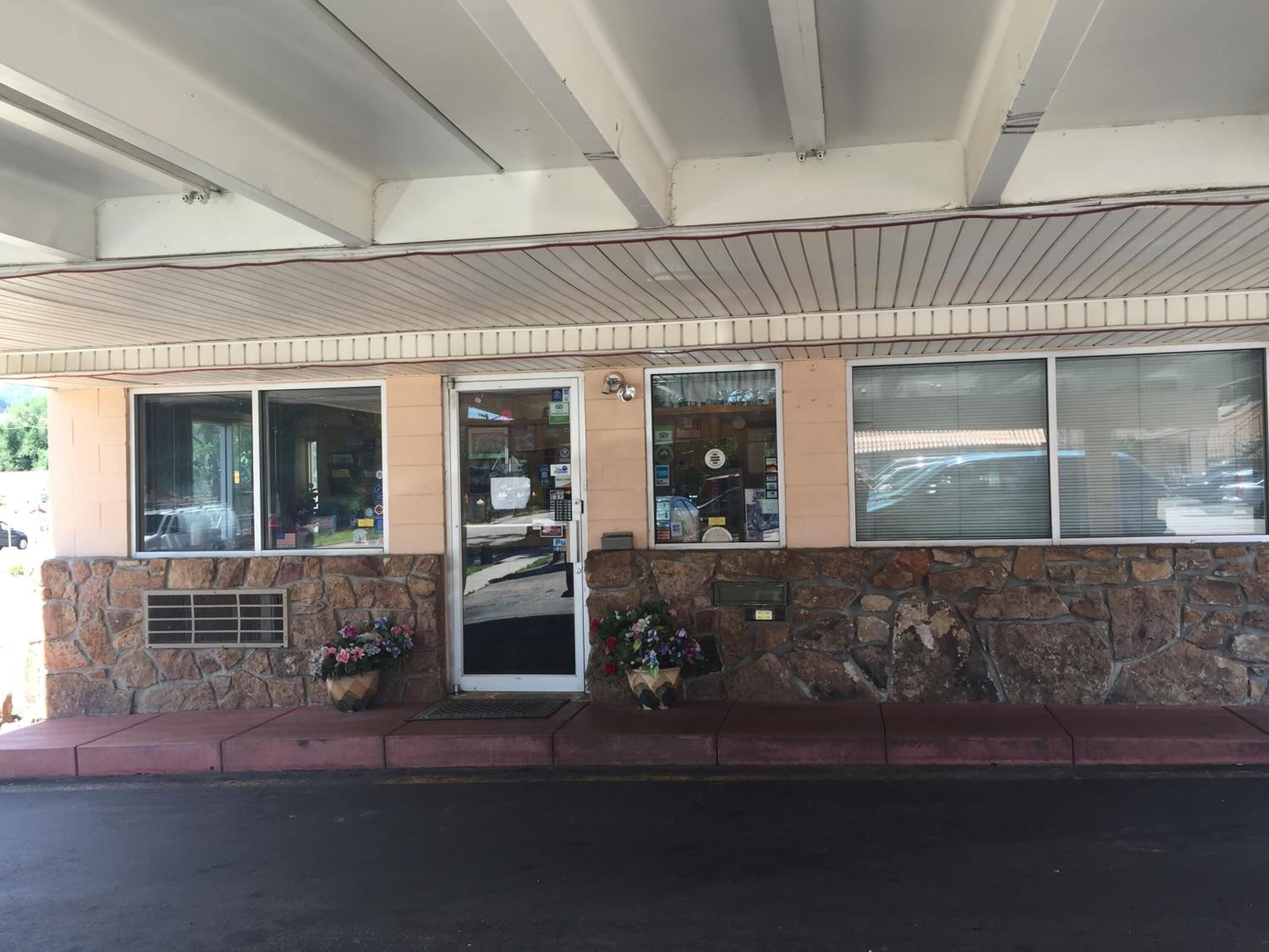 A building with a stone facade, a metal awning, and a door with a small window.