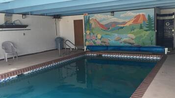 A swimming pool with a mural of mountains and trees on the wall.