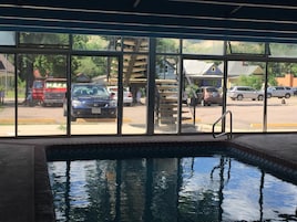 Piscina con vistas a coches aparcados y edificios.