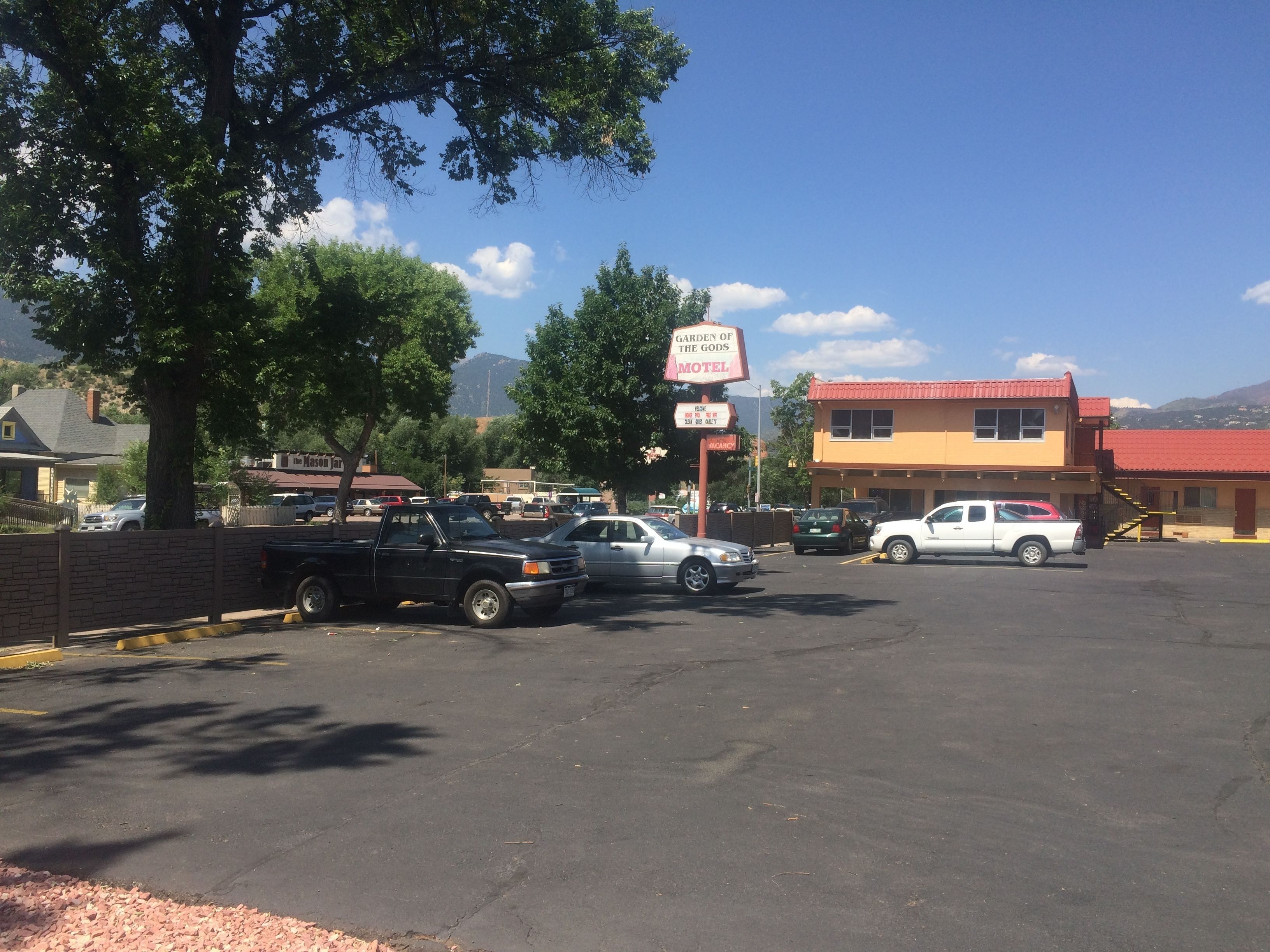Un motel avec une enseigne indiquant « Garden of the Gods Motel » et un toit rouge.