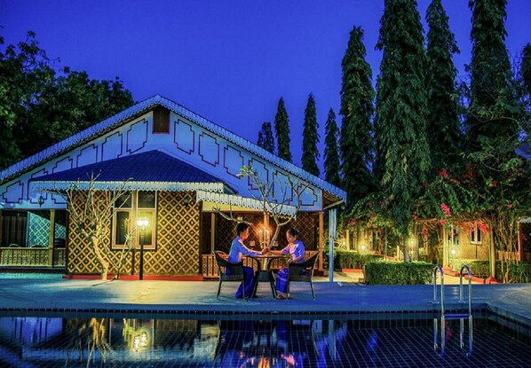Una piscina al aire libre, sillones reclinables de piscina