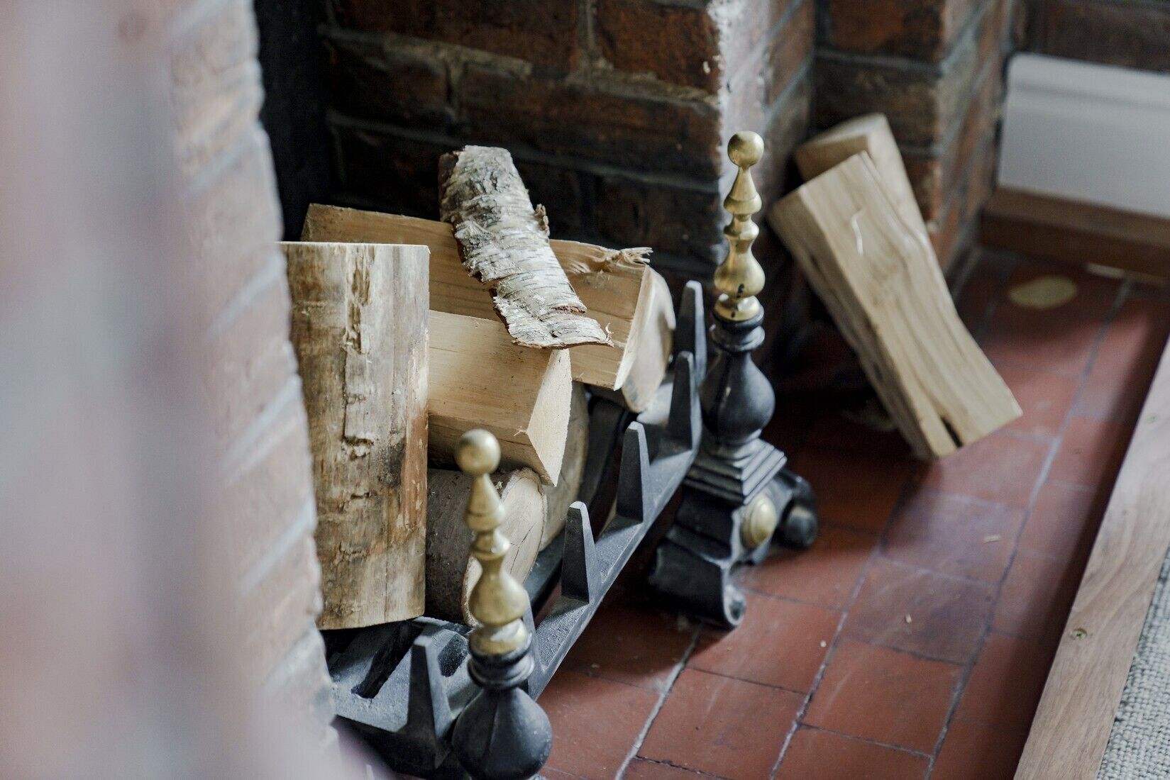 A fireplace with a brick wall and a tiled floor.