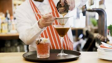 A bartender preparing a cocktail in a martini glass.
