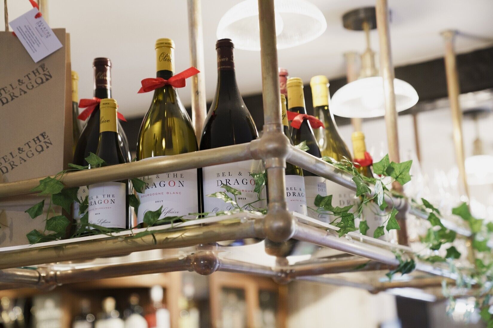 Una estantería para vinos con botellas etiquetadas como "BEL & THE DRAGON" y "Bourgeois Blanc" de 2017.