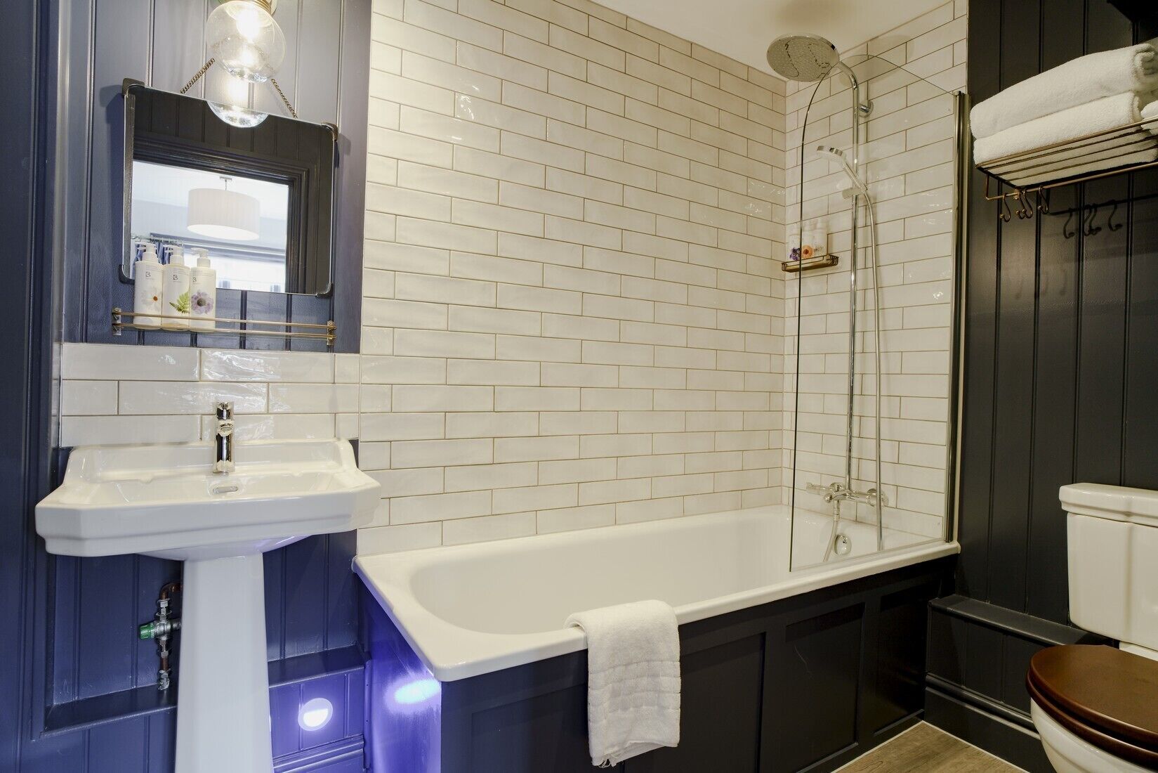 A bathroom with a white sink, a bathtub, and a shower.