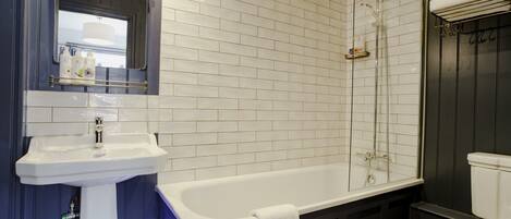 A bathroom with a white sink, a bathtub, and a shower.