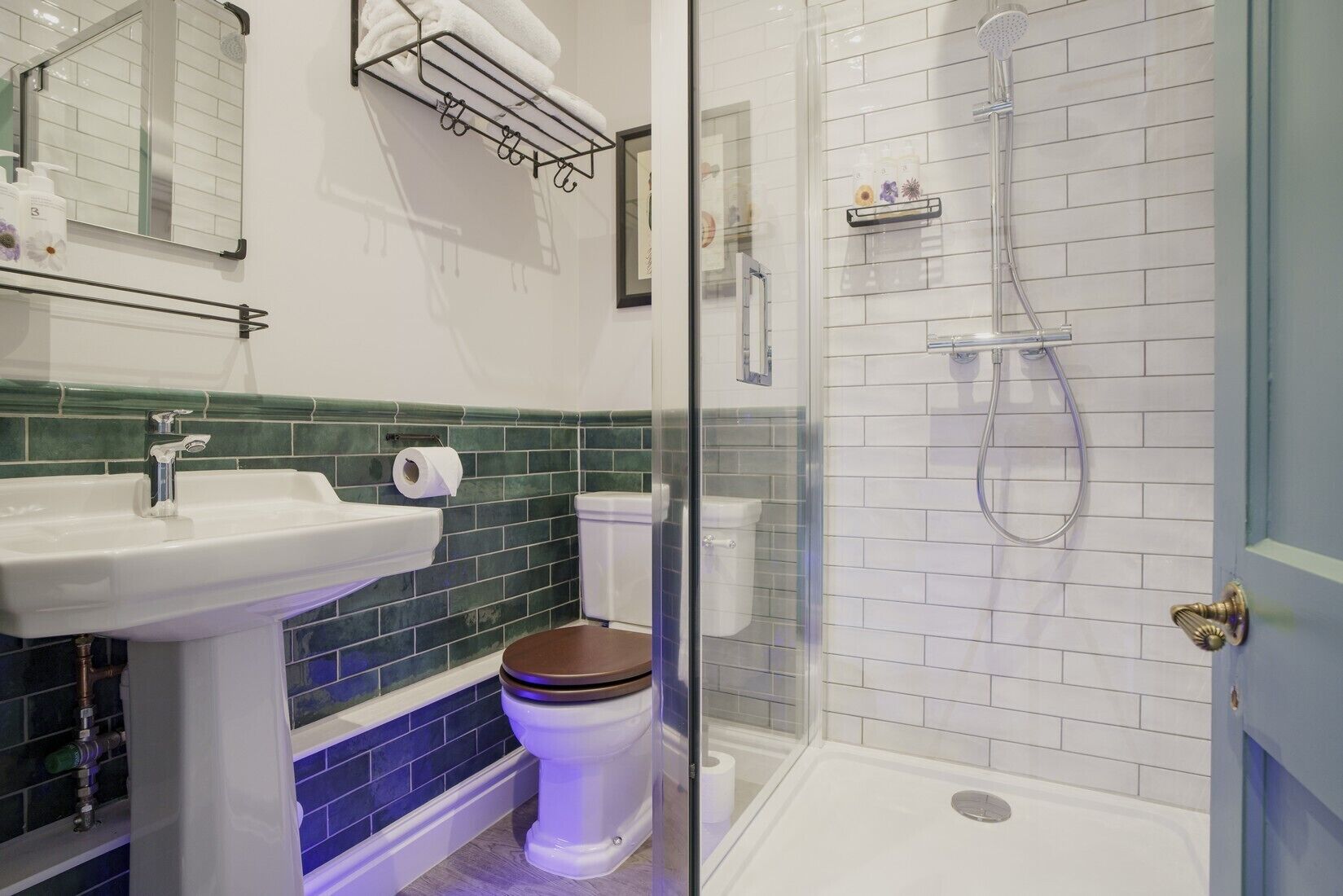 A bathroom with a white sink, a toilet, a shower, and a glass-enclosed shower area.