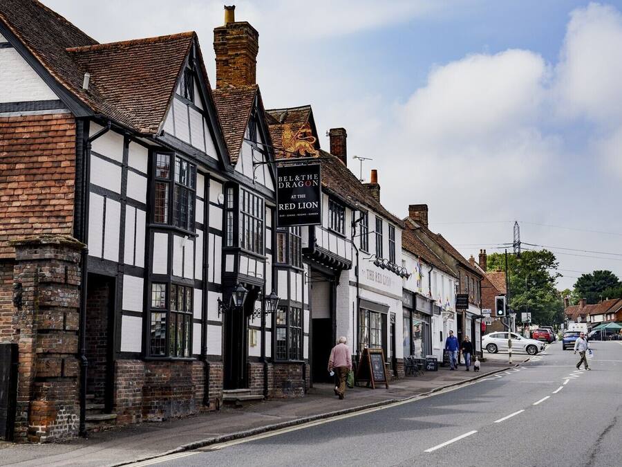 A traditional half-timbered building with a sign for 'BEL & THE DRAGON' and 'THE RED LION' pub.