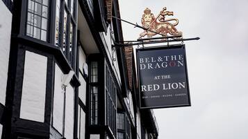 Experience the charm of Bel & The Dragon at The Red Lion, a traditional establishment with a unique lion-themed sign.