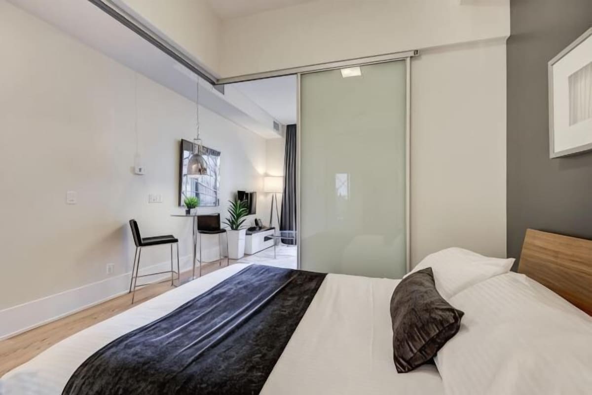 Una habitación de hotel moderna con cama, escritorio y puerta corredera.