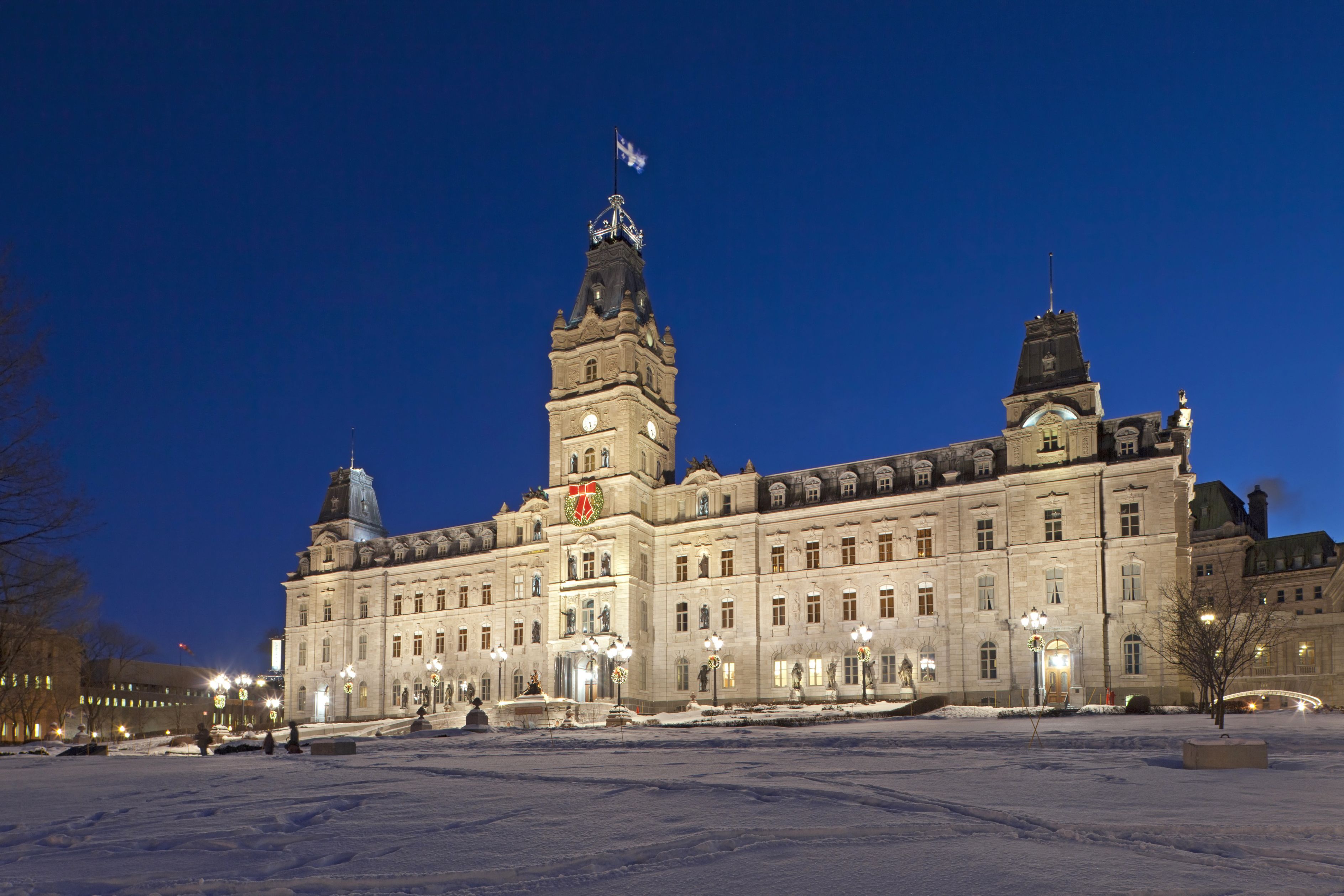A large, historic building with multiple towers and a central entrance, surrounded by a snow-covered plaza.