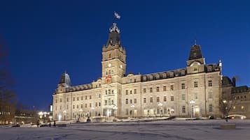 A large, historic building with multiple towers and a central entrance, surrounded by a snow-covered plaza.