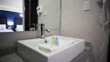 Ein Hotelbad mit einem weißen Waschbecken, einem Spiegel und einem Telefon.