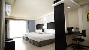 A hotel room with two beds, a desk, a chair, and a window. - Hotel Ha (Orizaba)