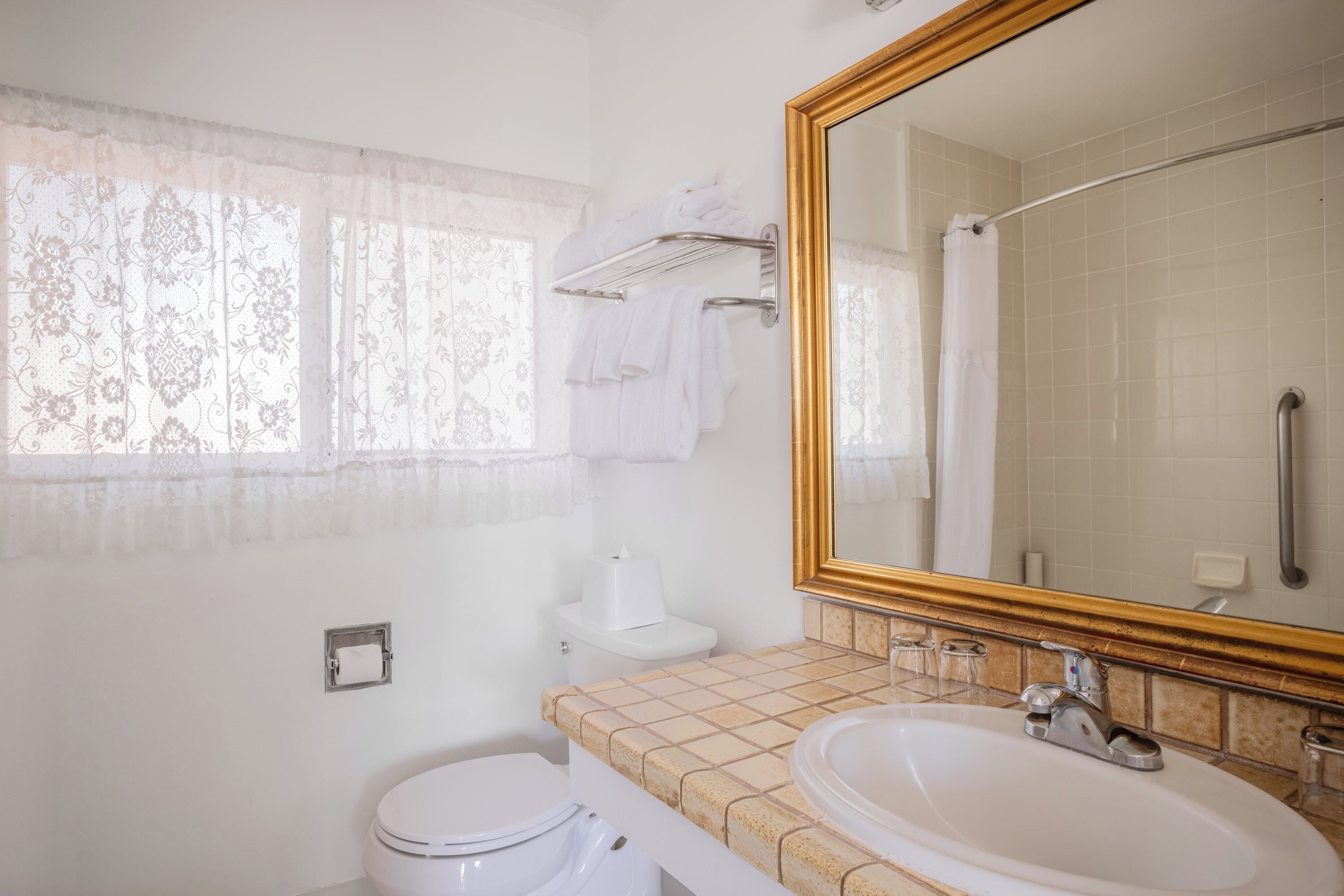 A bathroom with a toilet, sink, and mirror.
